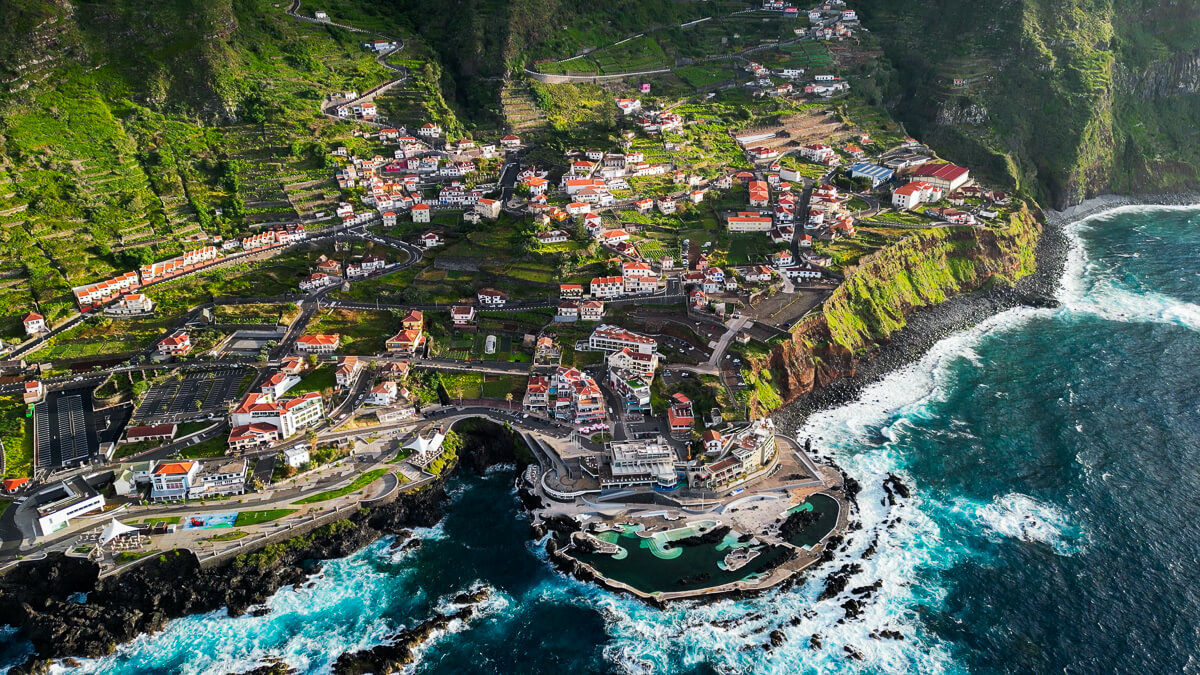 Drone shot of the village seixal with coastline, green nature and ocean view