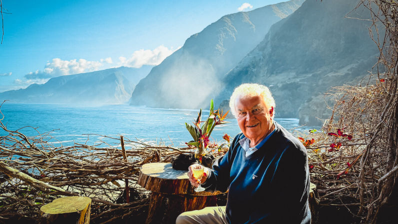 Happy man enjoying his drink on a viewpoint on madeira