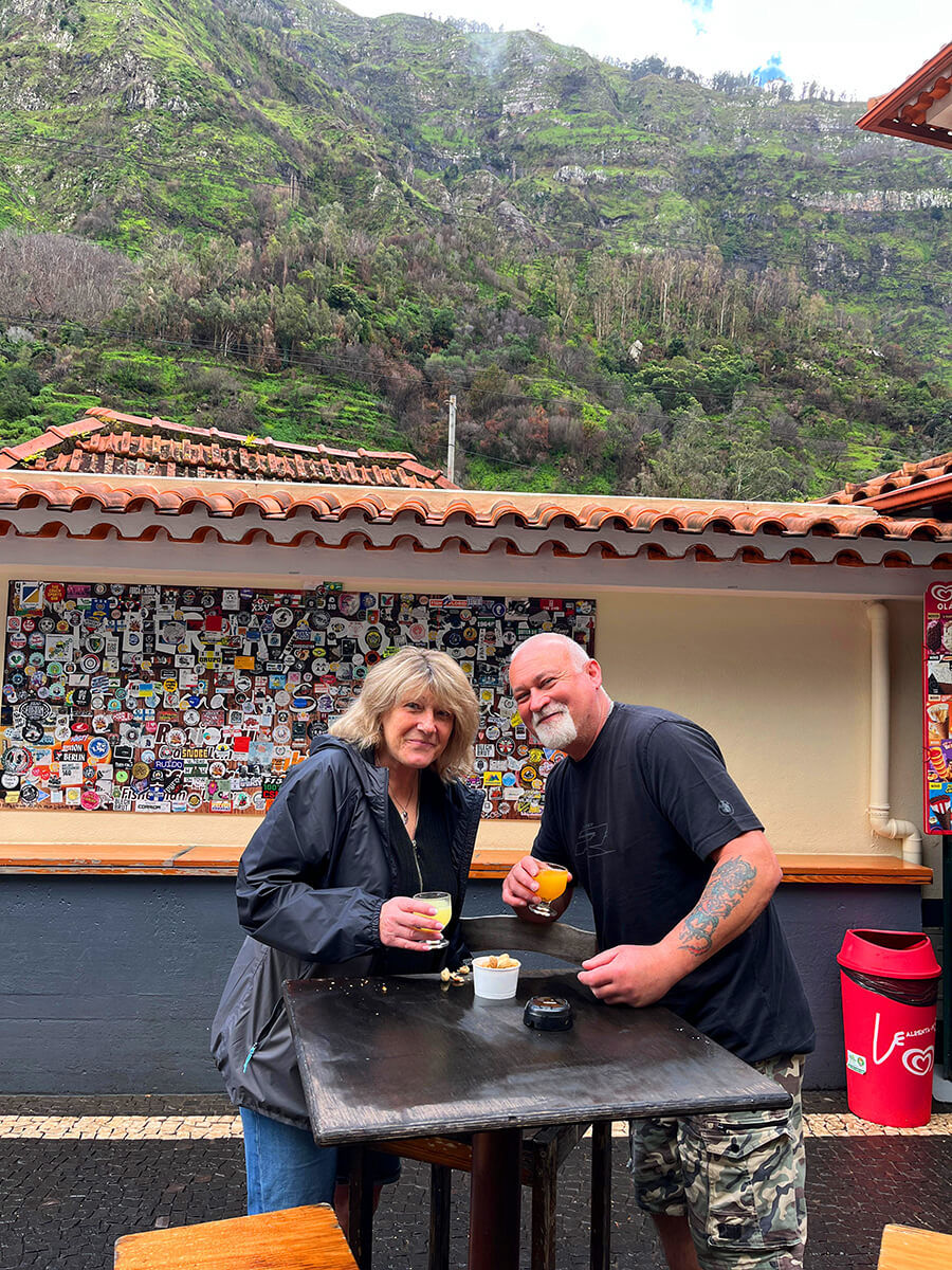 A massive waterfall dropping from a high cliff surrounded by green nature